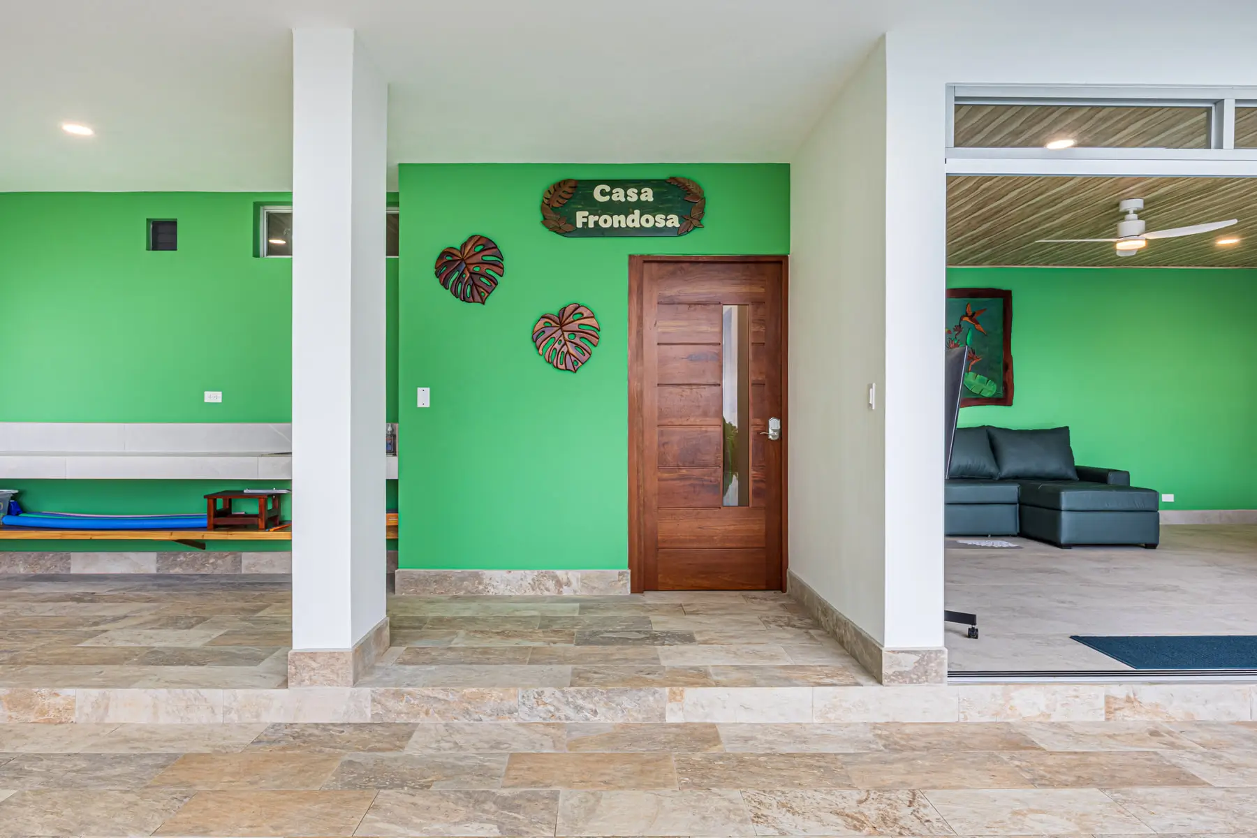The hardwood front door of the house, with the Casa Frondosa name plate beside it